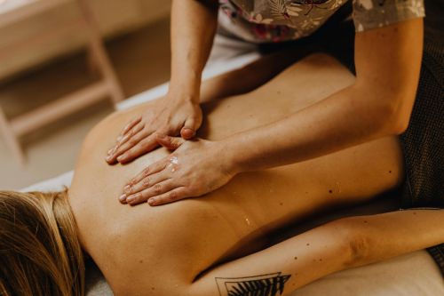 Close-up of a relaxing back massage at a spa with hands applying massage oil.