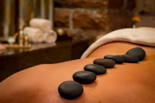 A serene spa setting with a woman receiving an arm massage, promoting relaxation and wellness.